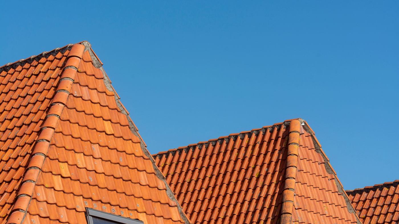 Toits en tuiles rouges sous un ciel bleu